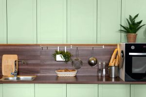 Detalhes de cozinha colorida com armários verdes.