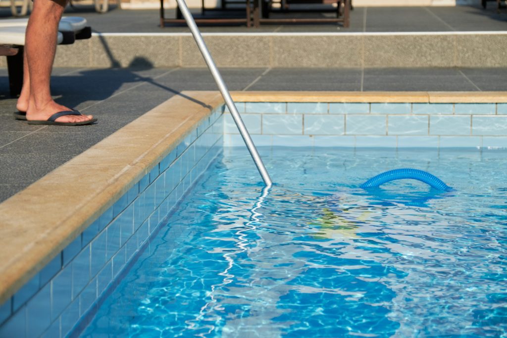 pessoa limpando a piscina com rede