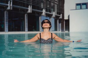 mulher aproveitando piscina de vidro.